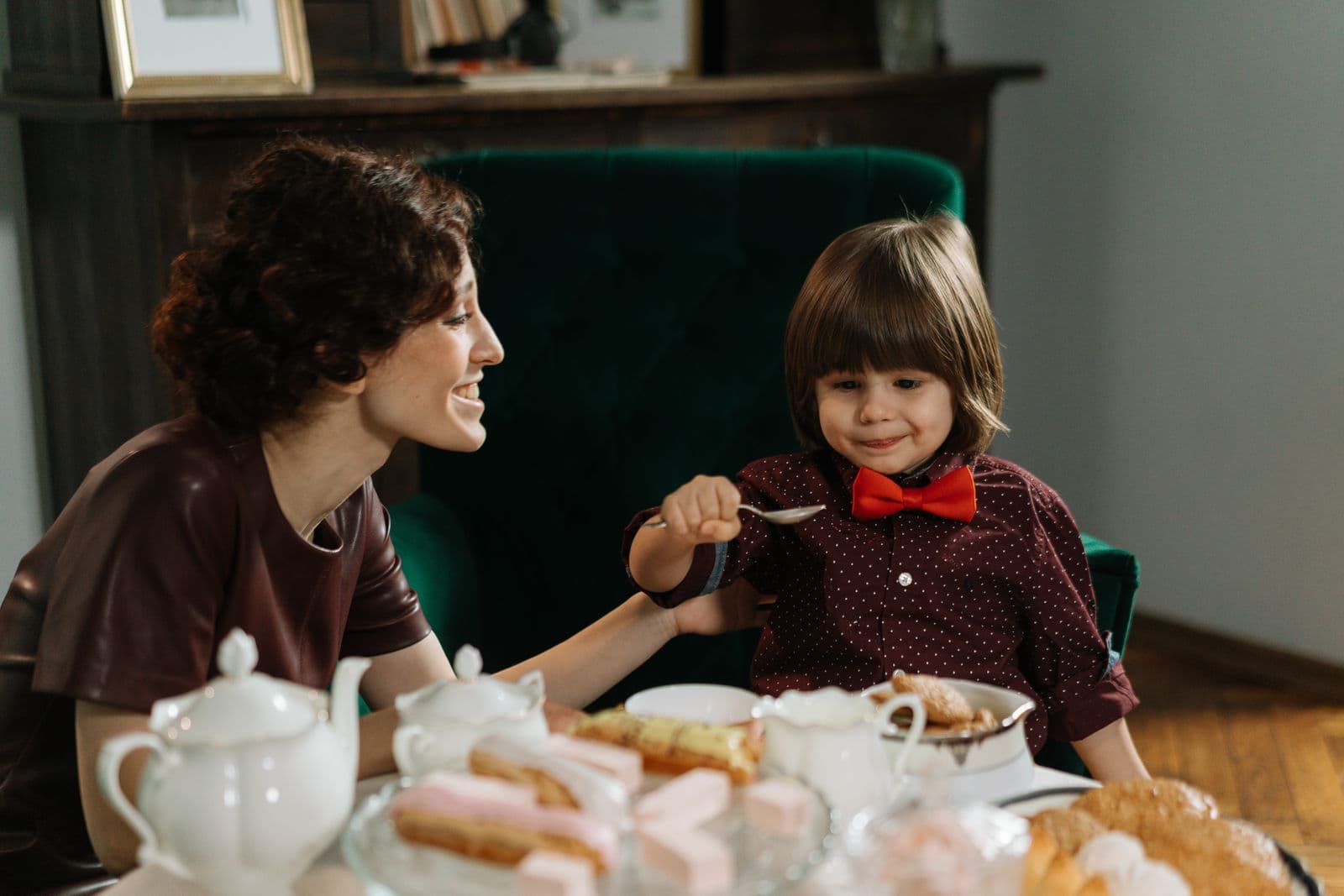Caregiver sitting at a table with a young child during a meal at home